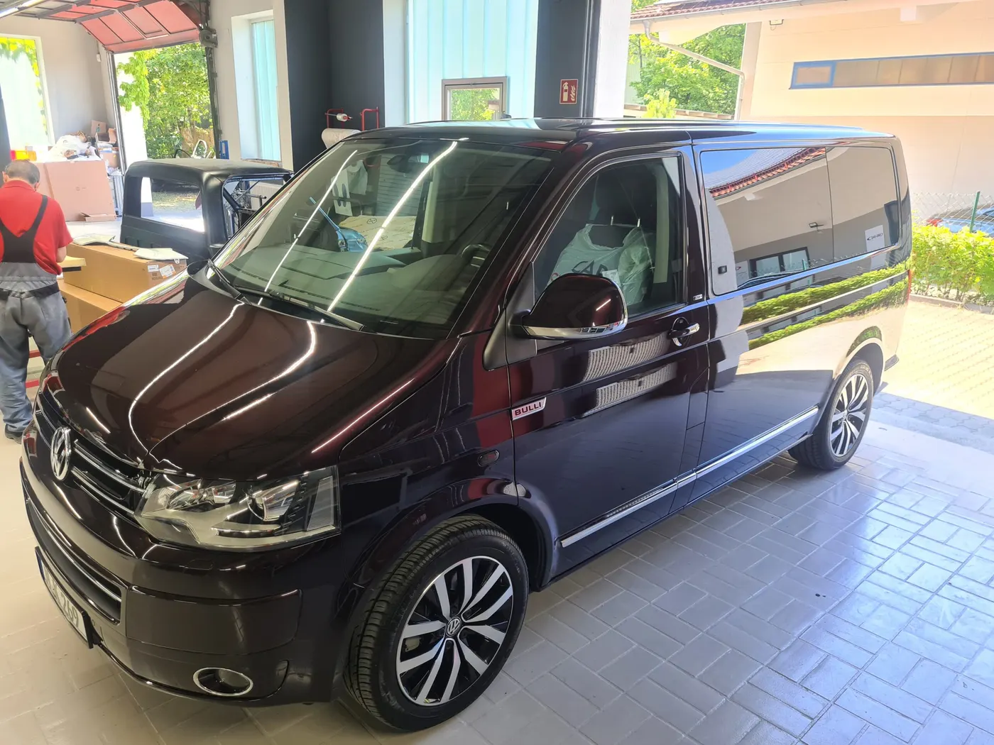 Fertig lackierter schwarzer VW-Bus im Hof der Lackprofi GmbH