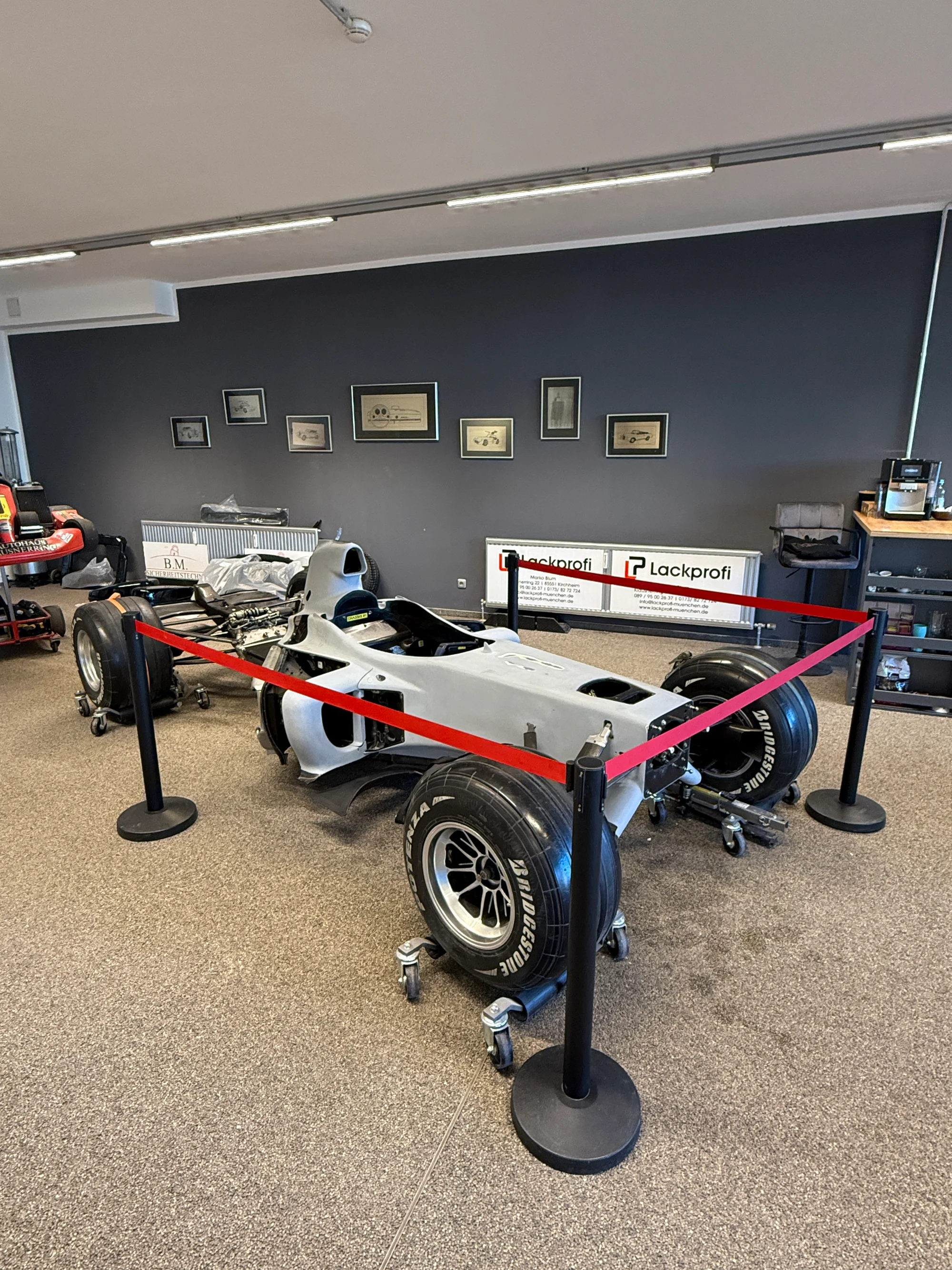 Ausstellung im Betrieb der Lackprofi GmbH mit Fahrzeug hinter Absperrung
