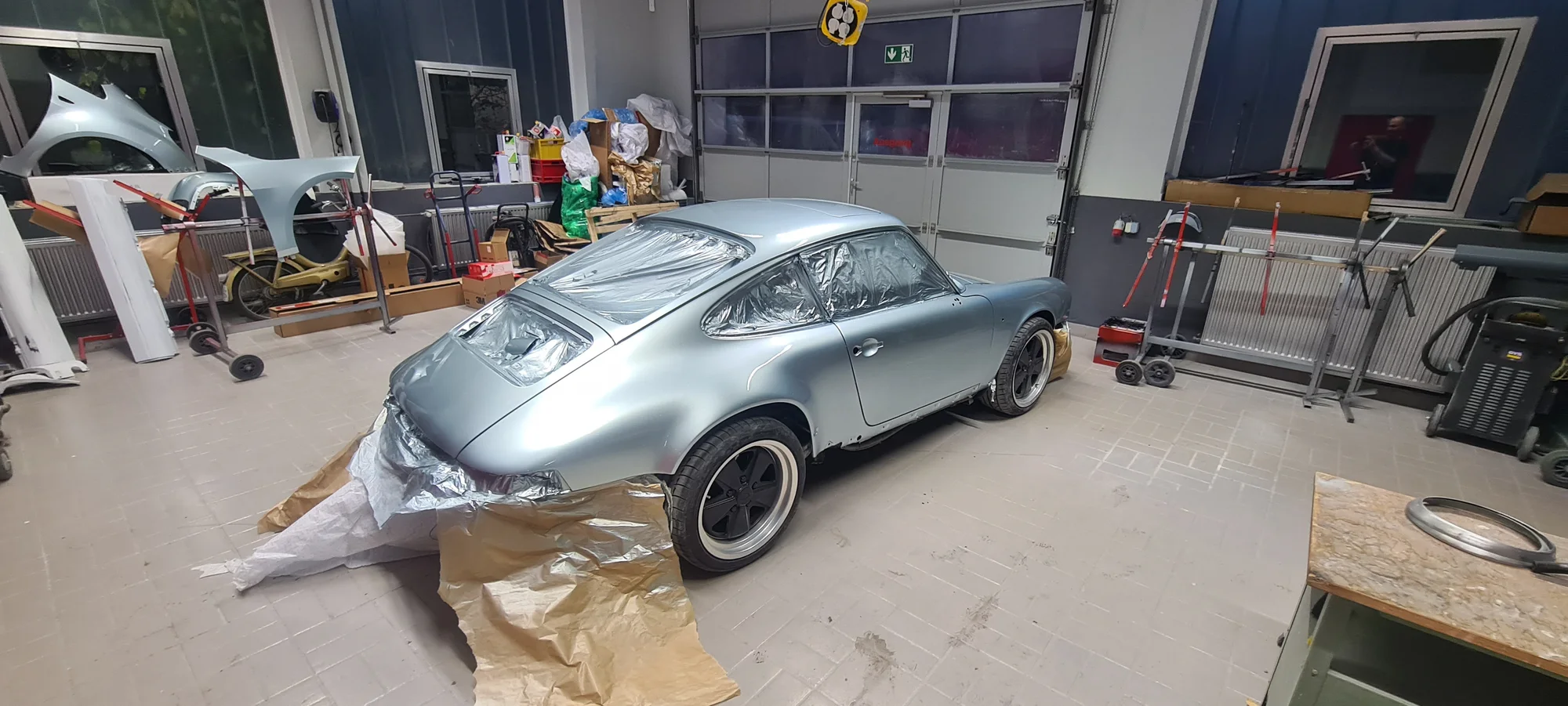 Silberner Porsche 911 mit abgedeckten Rädern in der Werkstatt in Kirchheim