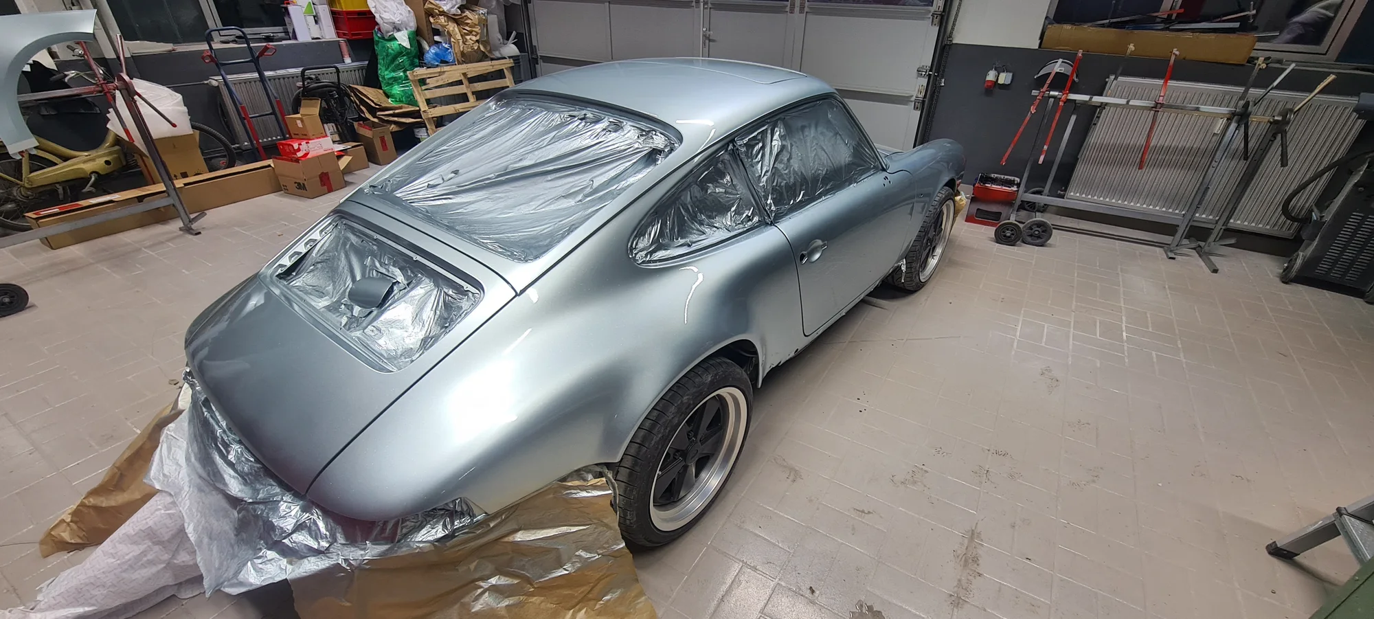 Heckansicht des silbern lackierten Porsche 911 in der Werkstatt